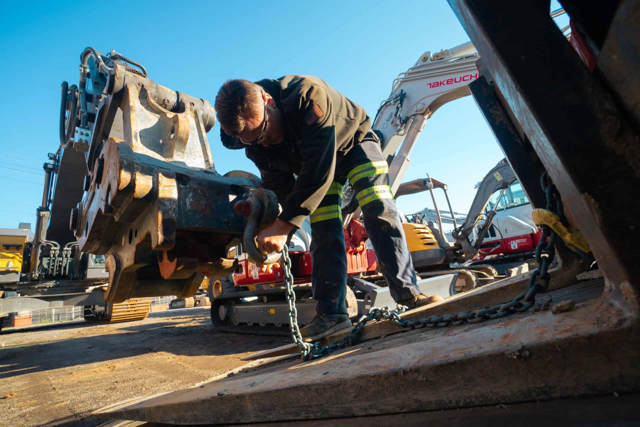 Construction worker inspecting heavy machinery at a construction site.