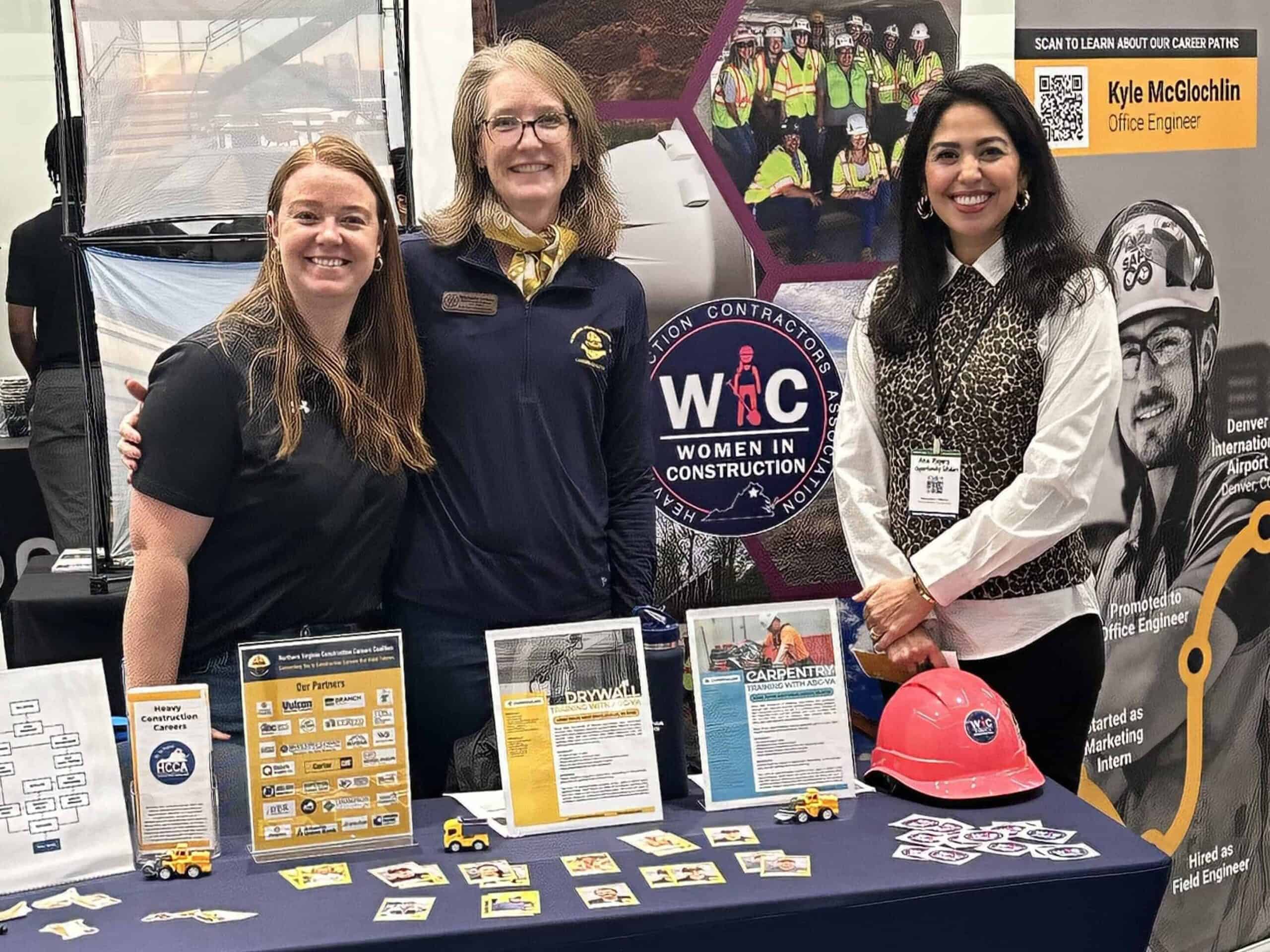 Three women at NV3C career fair booth promoting women in construction.